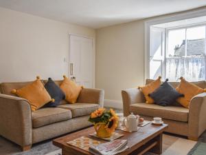 a living room with two couches and a coffee table at The Cottage Highfield in Rothbury