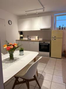 ベンスハイムにあるModerne Souterrainwohnungの花瓶に花が飾られたテーブルのあるキッチン
