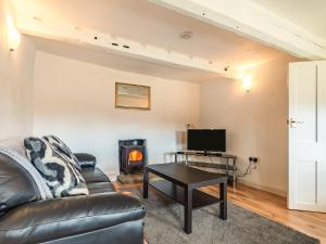 een woonkamer met een bank en een open haard bij Arthur Bear - Uk37992 in Greenhow Hill