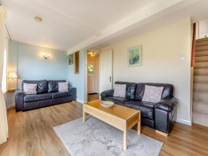 a living room with two leather couches and a coffee table at The Cottage in Fairlight