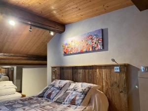 Un dormitorio con una cama y un cuadro en la pared. en Vieille Bergerie 3, en Le Fernuy