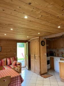 a kitchen and living room with a wooden ceiling at Vieille Bergerie 5 in Le Fernuy
