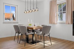 une salle à manger avec une table et des chaises dans l'établissement BALANCED Münsing Apartments, vollausgestatte Ferienwohnungen Nähe Starnberger See, à Münsing