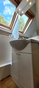 a bathroom with a sink and two windows at Maison de caractère - L'évasion forestière in Baguer-Pican +25 photos