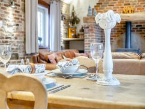un tavolo con bicchieri e un vaso con fiori sopra di The Old Granary a Cumberworth