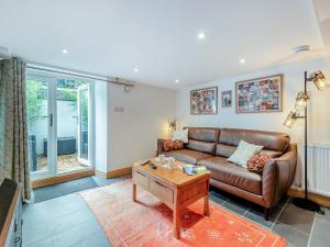 Una sala de estar con un sofá y una mesa de café. en Stanley Cottage, en Windermere