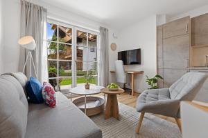 a living room with a couch and a table at BALANCED Münsing Ferienwohnungen Nähe Starnberger See in Münsing am Starnberger See