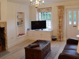 a living room with a tv and a couch at Starry Cottage in Bakewell