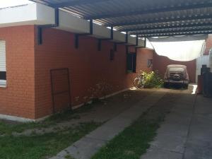 a brick building with a car parked under a roof at Casa Milu in Mina Clavero +2 photos