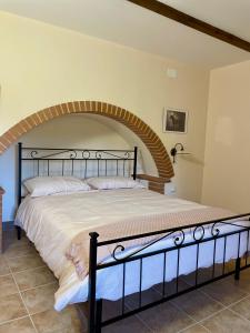 a bedroom with a large bed with an arch at La Dimora di Armida in Torricella Peligna
