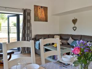 a living room with a couch and a table and chairs at Ty Isaf Cottage in Ffair-fâch