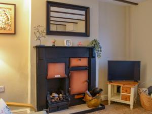 a living room with a fireplace and a television at Seashell Cottage - Uk48616 in Flamborough