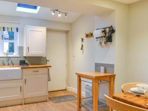a kitchen with a sink and a table in a room at Seashell Cottage - Uk48616 in Flamborough +13 photos