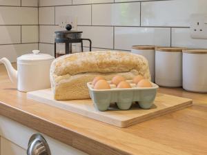 a loaf of bread and a bowl of eggs on a counter at Lane Ends Cottage in Disley