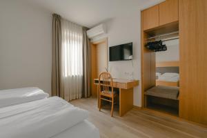 a hotel room with a desk and a bed and a bedroom at Hotel Post Gries in Bolzano +99 photos