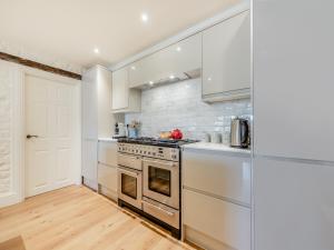 a kitchen with stainless steel appliances and white cabinets at The Anchorage in Pembroke +40 photos