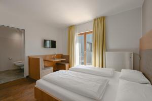 a bedroom with two beds and a desk and a sink at Hotel Post Gries in Bolzano +95 photos