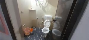 a small bathroom with a toilet in a stall at Gokarna Holiday Homes in Gokarna +6 photos