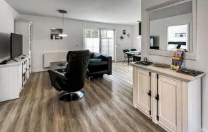 un salon avec une chaise noire et une télévision dans l'établissement Ferienhaus Fuhlendorf, à Fuhlendorf