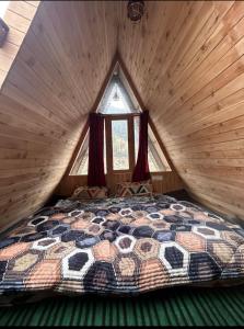 a bedroom with a large bed in a log cabin at Skytouch cottage stargazing in Jibhi