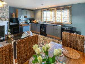 a kitchen and living room with a table and chairs at Garden Cottage in Tain