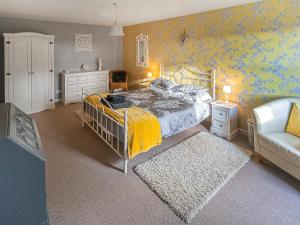 a bedroom with a bed and a couch and a chair at Garden Cottage in Tain