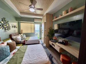a bedroom with two beds and a living room at Vacay shine tagaytay staycation in Kaybagal