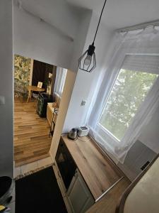 a room with a large window and a wooden floor at Smaragd Apartman in Kaposvár