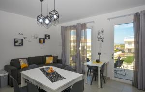 a living room with a couch and a table at Cozy Apartment In Marzamemi With Wifi in Marzamemi