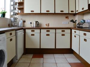 a kitchen with white cabinets and a dishwasher at Robinson in Keswick