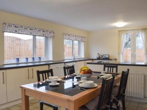 una cucina con tavolo e sedie in legno di Brookside Cottage a Forton