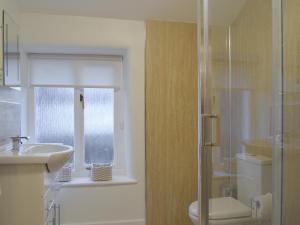 un bagno con wc, lavandino e doccia di Brookside Cottage a Forton Altre 9 foto