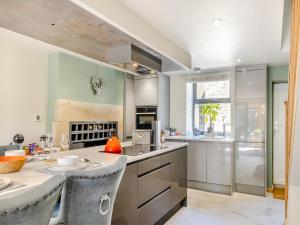 a kitchen with a large island with a table and chairs at Squirrel Cottage in Glossop