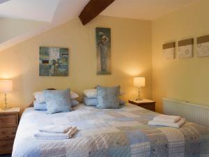 a bedroom with a large bed with towels on it at The Shippon in Burscough +10 photos