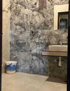 a bathroom with a sink and a stone wall at Hotel Simran Desert View Haveli in Pushkar