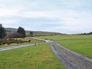 a dirt road in a field next to a grass field at Felbridge Cottage in Bardon Mill