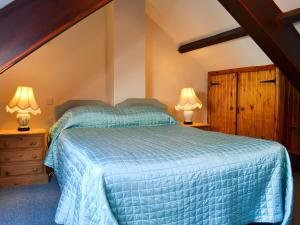 a bedroom with a bed and two lamps on night stands at Felbridge Cottage in Bardon Mill