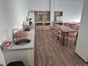 a kitchen with a sink and a table and chairs at Albergue Camino Espiritual in Ribadumia