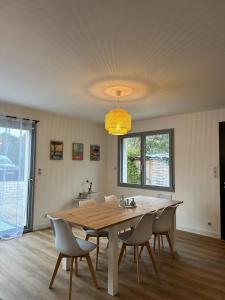 ein Esszimmer mit einem Holztisch und Stühlen in der Unterkunft Le Nid Des Grèves avec jacuzzi in Langueux + 16 Fotos