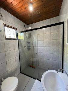 a bathroom with a shower and a toilet and a sink at Pousada da Vovó (Nelci) in Ponta Grossa