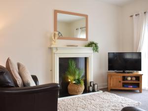a living room with a fireplace with a mirror at No 8 Harney Peak in Portinscale