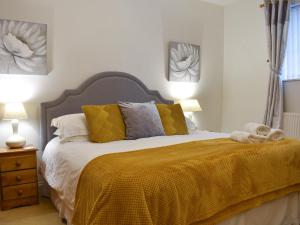 a bedroom with a bed with a yellow blanket at No 8 Harney Peak in Portinscale