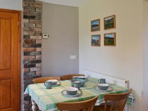 a table with bowls and cups on top of it at Garden Farm Cottage in Ilam