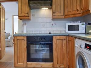 a kitchen with a dishwasher and a microwave at Garden Farm Cottage in Ilam +9 photos