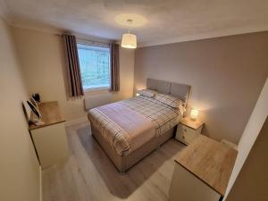 インバネスにあるModern City Apartmentのベッドと窓のある小さな寝室