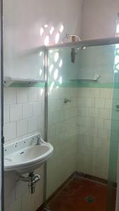 a bathroom with a sink and a mirror at Quarto em casa arborizada in Belém +9 photos