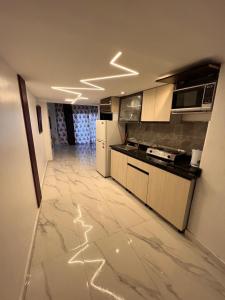 a large kitchen with marble flooring in a apartment at Sky Sokhna -قمة التجربة الفاخرة مع بورتو رينتال in Ain Sokhna