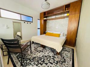 a bedroom with a bed and a chair and a mirror at Casa Bene Villas in Isla Mujeres