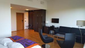 ein Wohnzimmer mit Sofa, Tisch und Stühlen in der Unterkunft Hotel Montebello in Oslo