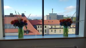dos jarrones con flores sentados en el alféizar de la ventana en Hotel Montebello, en Oslo